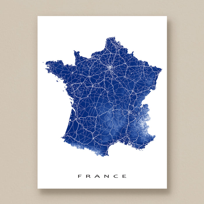 Map of France with blue roads on a white background, displayed on a beige wall.