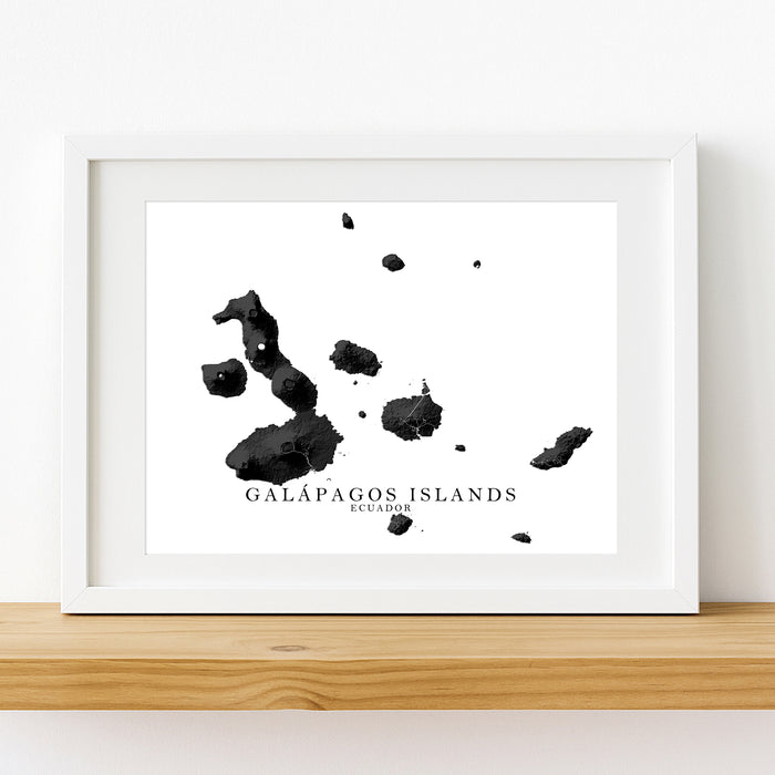 Framed map of the Galápagos Islands on a white wall.