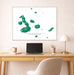Framed map of Galapagos Islands on a wall above a desk with a laptop and lamp.