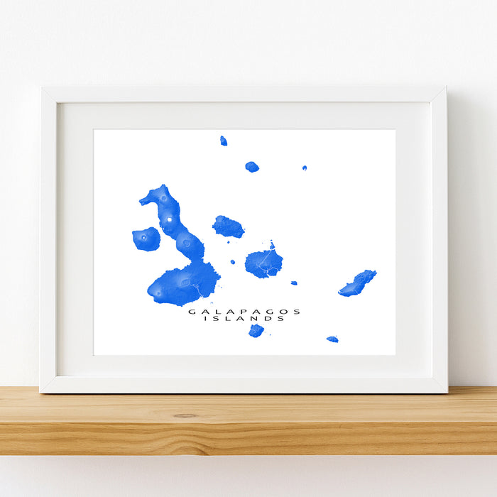 Framed artwork of blue watercolor splashes labeled 'Galapagos Islands' on a white background.