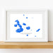 Framed artwork of blue watercolor splashes labeled 'Galapagos Islands' on a white background.