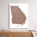 Map of Georgia on a white wall above a wooden shelf.