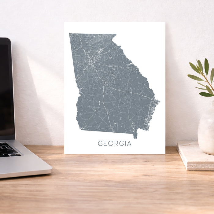 Map of Georgia on a desk with a laptop and plant