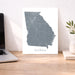 Map of Georgia on a desk with a laptop and plant