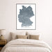 Framed map of Germany on a wall above a bed in a bedroom.