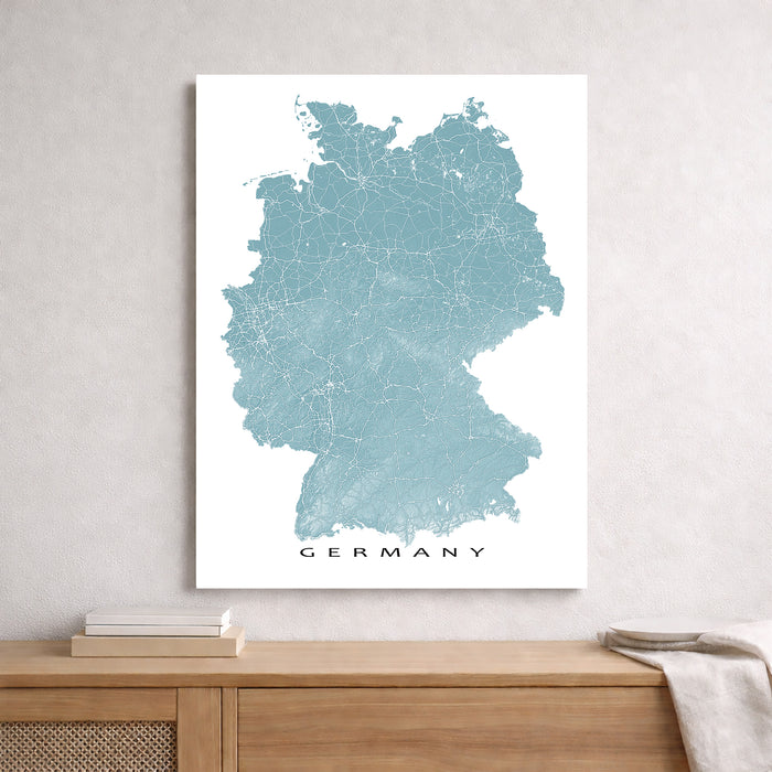 Map of Germany on a white wall above a wooden cabinet.