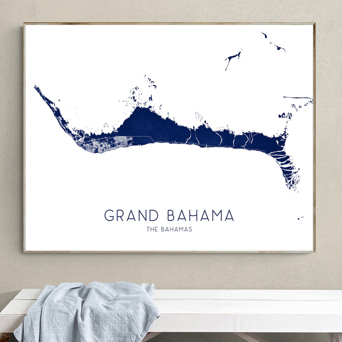 Framed map of Grand Bahama on a wall above a white bench.