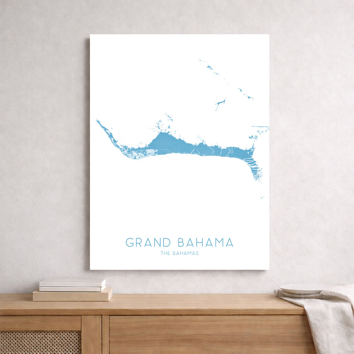 Map of Grand Bahama on a white wall above a wooden shelf.