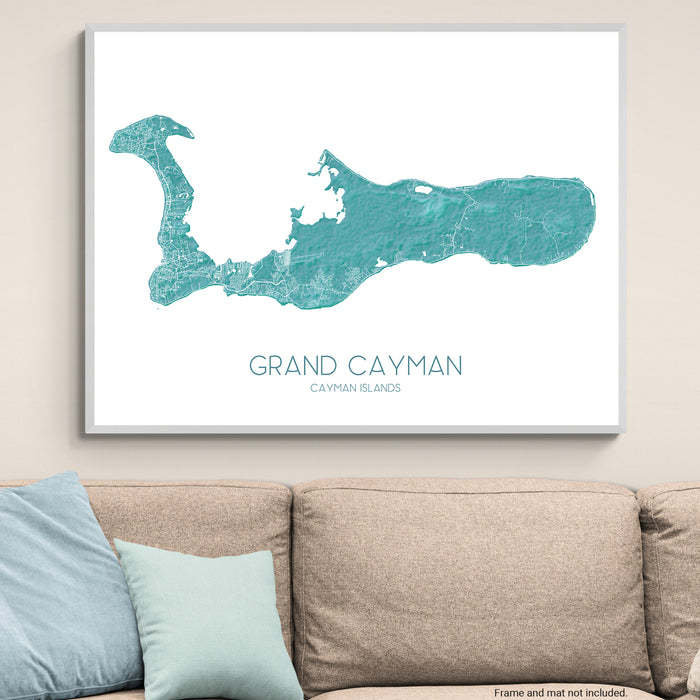 Framed map of Grand Cayman on a wall above a beige sofa with light blue pillows.