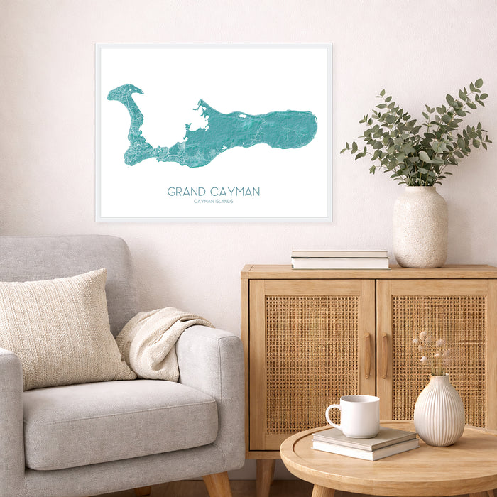 Living room with a map of Grand Cayman on the wall, a couch, and a side table with a vase and books.