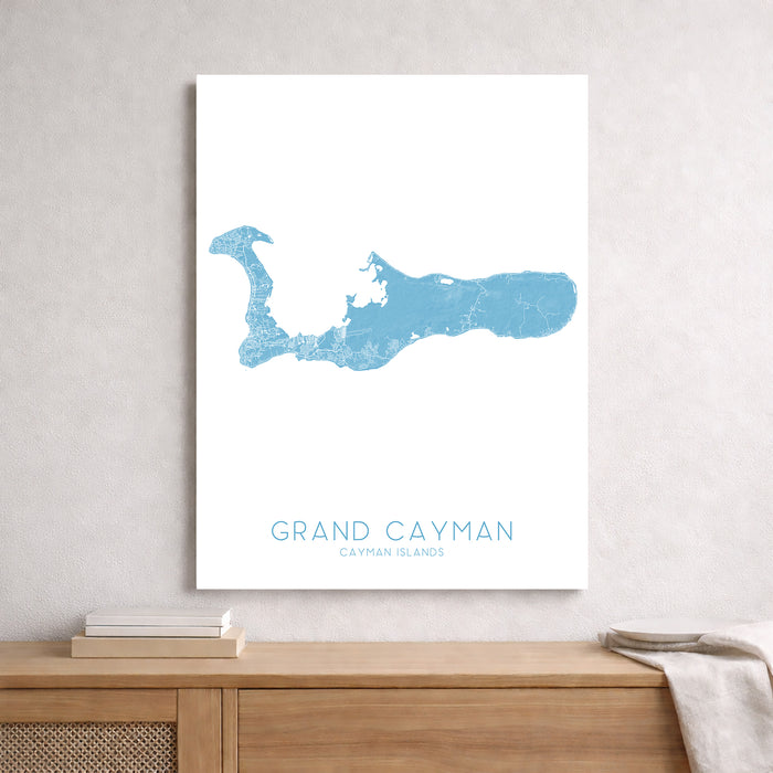 Map of Grand Cayman on a white wall above a wooden surface