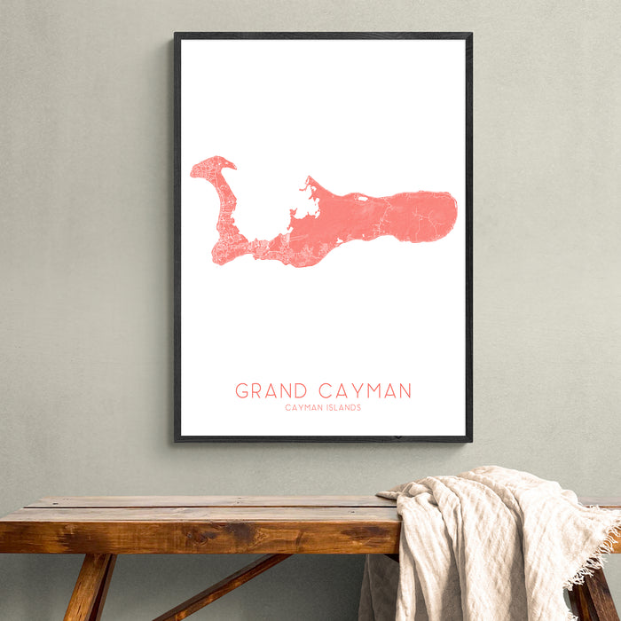 Framed map of Grand Cayman on a wall above a wooden bench.