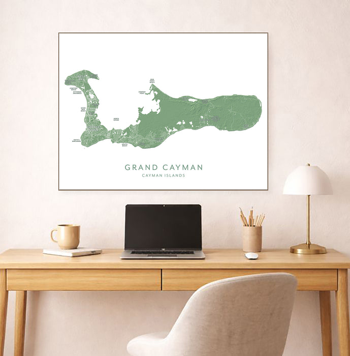 Map of Grand Cayman on a wall above a desk with a laptop and lamp.