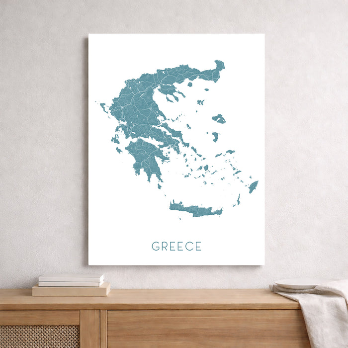 Framed map of Greece on a wall above a wooden shelf.