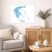 Living room with a gray sofa, wooden cabinet, and framed map of Greece on the wall.