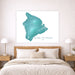 Framed map of the Island of Hawaii on a wall above a bed.