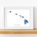 Framed artwork of a blue map of Hawaii on a white background