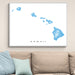 Framed map of Hawaii on a wall above a beige sofa with light blue pillows.