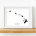 Framed artwork of a map of Hawaii on a white wall.