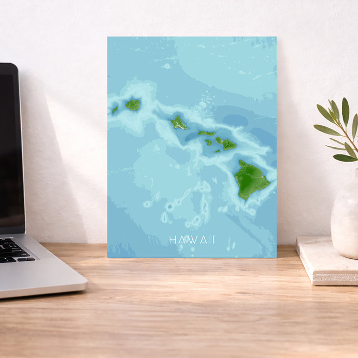 Map of Hawaii on a wall above a desk with a laptop and plant.