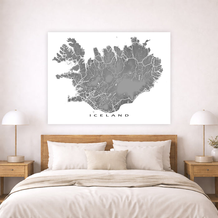 Map of Iceland on a wall above a bed in a bedroom setting