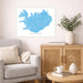 Living room with a map of Iceland on the wall, a couch, and a wooden cabinet.