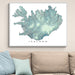 Framed map of Iceland on a wall above a sofa with light blue cushions.