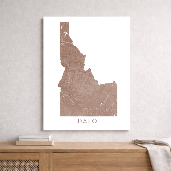 Map of Idaho on a white wall above a wooden shelf.