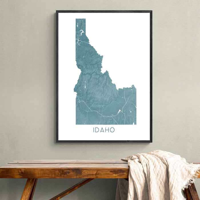 Framed map of Idaho on a wall above a wooden bench.
