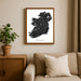 Framed map of Ireland on a wall above a sofa with a plant beside it.
