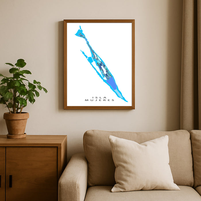 Framed map of Isla Mujeres on a wall above a beige sofa with a plant beside it.