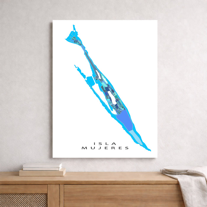 Map of Isla Mujeres in blue on a white background, framed and leaning against a light gray wall.