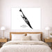 Framed artwork of a silhouette of Isla Mujeres, Mexico on a wall above a bed.