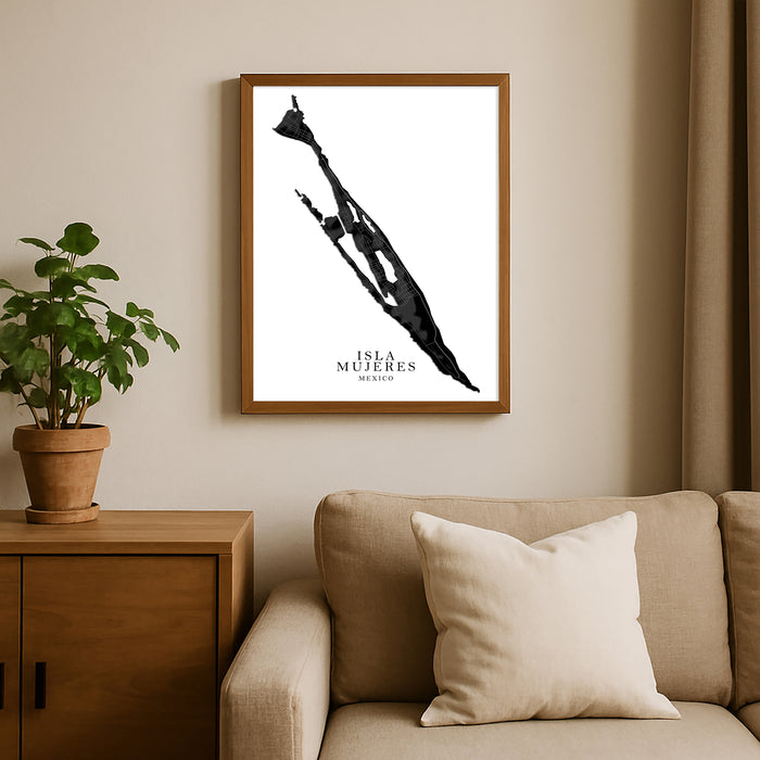 Framed artwork of a map of Isla Mujeres Mexico on a wall above a sofa with a plant beside it.