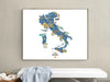 Framed map of Italy on a wall above a white bench with a basket and towel.