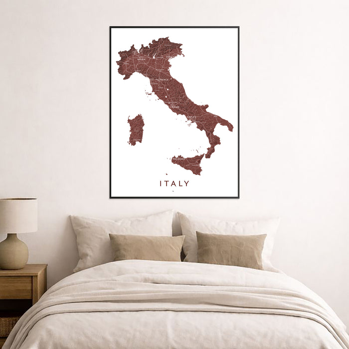 Framed map of Italy on a wall above a bed