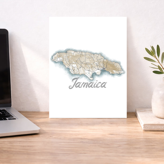 Map of Jamaica on a desk with a laptop and plant