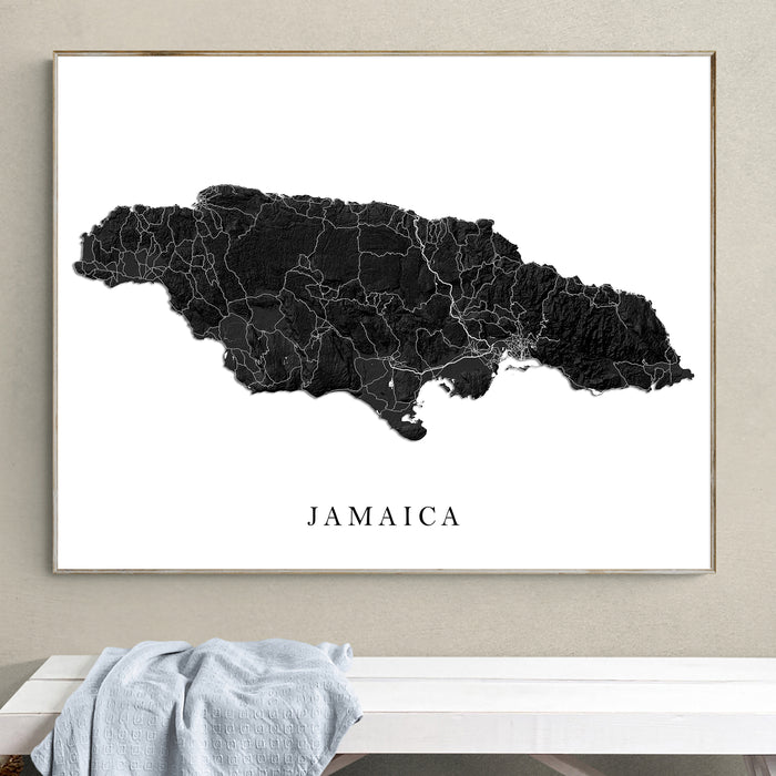 Framed map of Jamaica on a wall above a white bench.