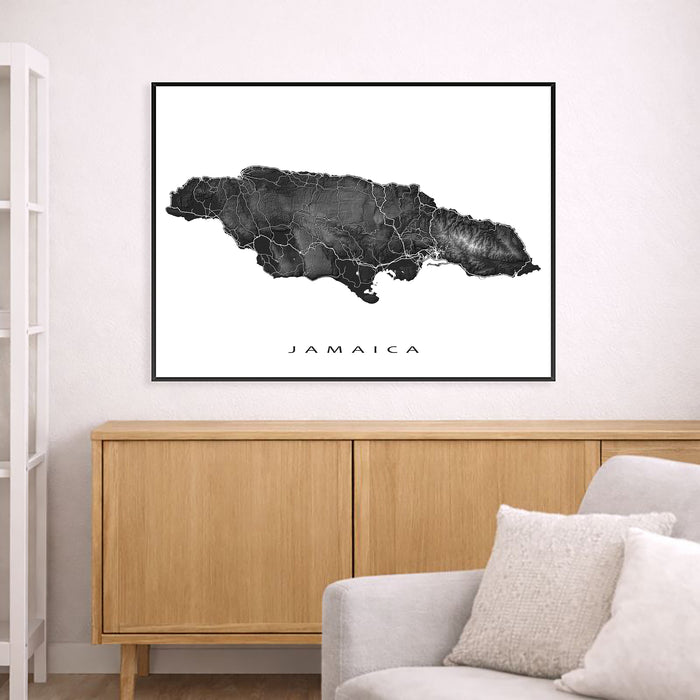 Framed map of Jamaica on a wall above a wooden cabinet and sofa.