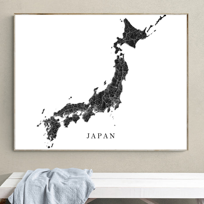Framed map of Japan on a wall above a white bench.