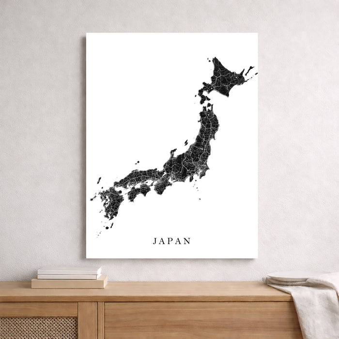 Map of Japan on a white wall above a wooden shelf.