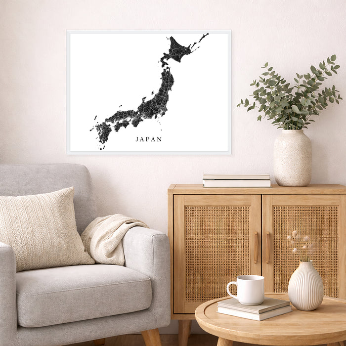 Living room with a map of Japan on the wall, a couch, and a side table with a vase and books.