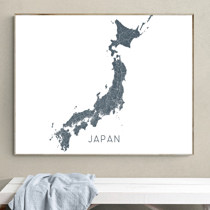 Framed map of Japan on a wall above a white bench.