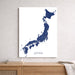 Map of Japan on a white wall above a wooden shelf.