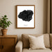 Framed artwork of a black coral with 'Kauai' text on a wall above a beige sofa.
