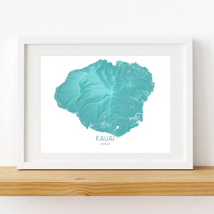 Framed map of Kauai, Hawaii on a white wall.