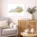 Framed map of Kentucky on a wall above a sofa with a wooden cabinet and table in the foreground.