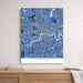 Map of London with blue mosaic pattern on a white wall above a wooden shelf.