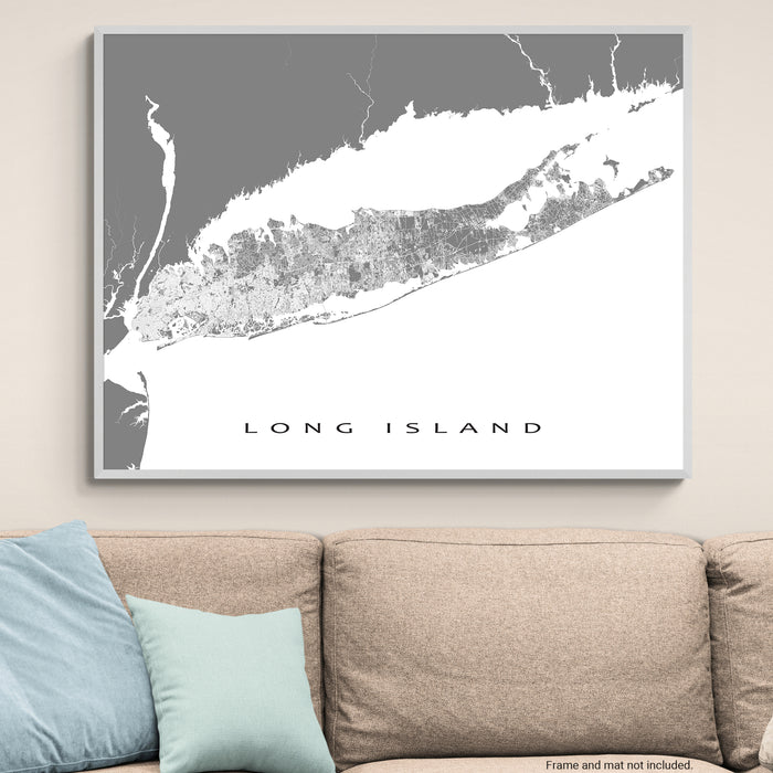 Framed map of Long Island on a wall above a beige sofa with blue pillows.