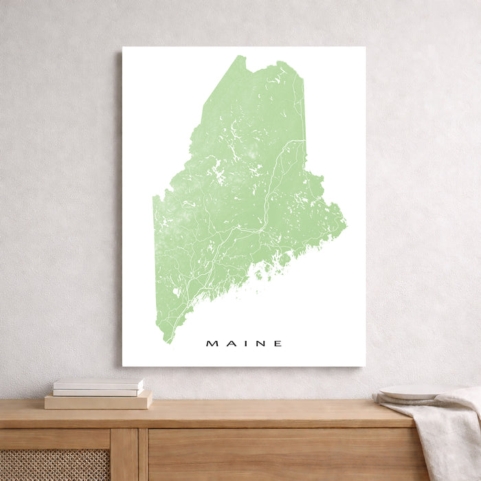 Map of Maine on a white background, framed above a wooden surface.